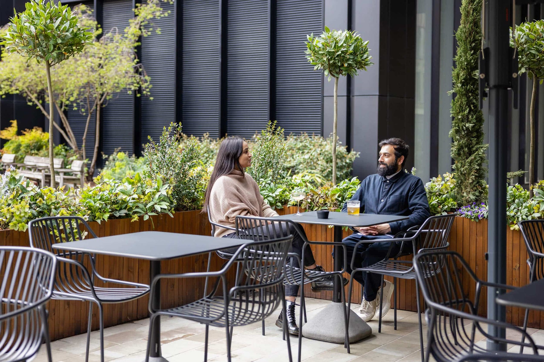 Bespoke Outdoor Bar Seating Area With Oak Coloured planters and seating.