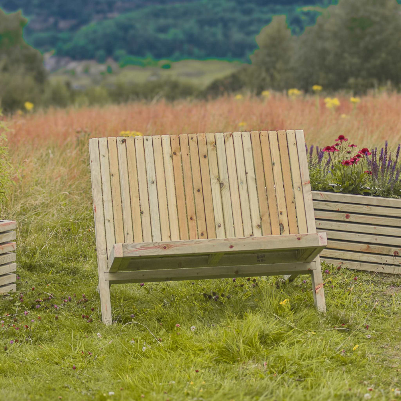 Rustic Garden Bench placed in a lush green garden. Made from durable fsc-timber. The bench is designed in an Adirondack style for comfort. 