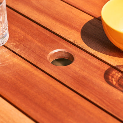 Close-up view of a parasol hole on a hardwood garden table made from Sapele wood.