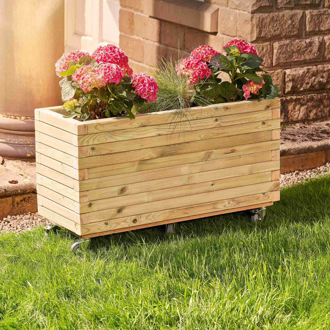 A rectangular wooden planter filled with vibrant flowers. The durable timber planter has a modern, sleek design and is placed in a garden.