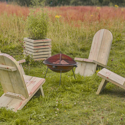 A cosy outdoor setup featuring a firepit, rustic timber camp chairs, and the centrepiece—a small square wooden slatted planter holding a tall, vibrant green plant, perfect for adding a touch of contemporary style to any outdoor space.