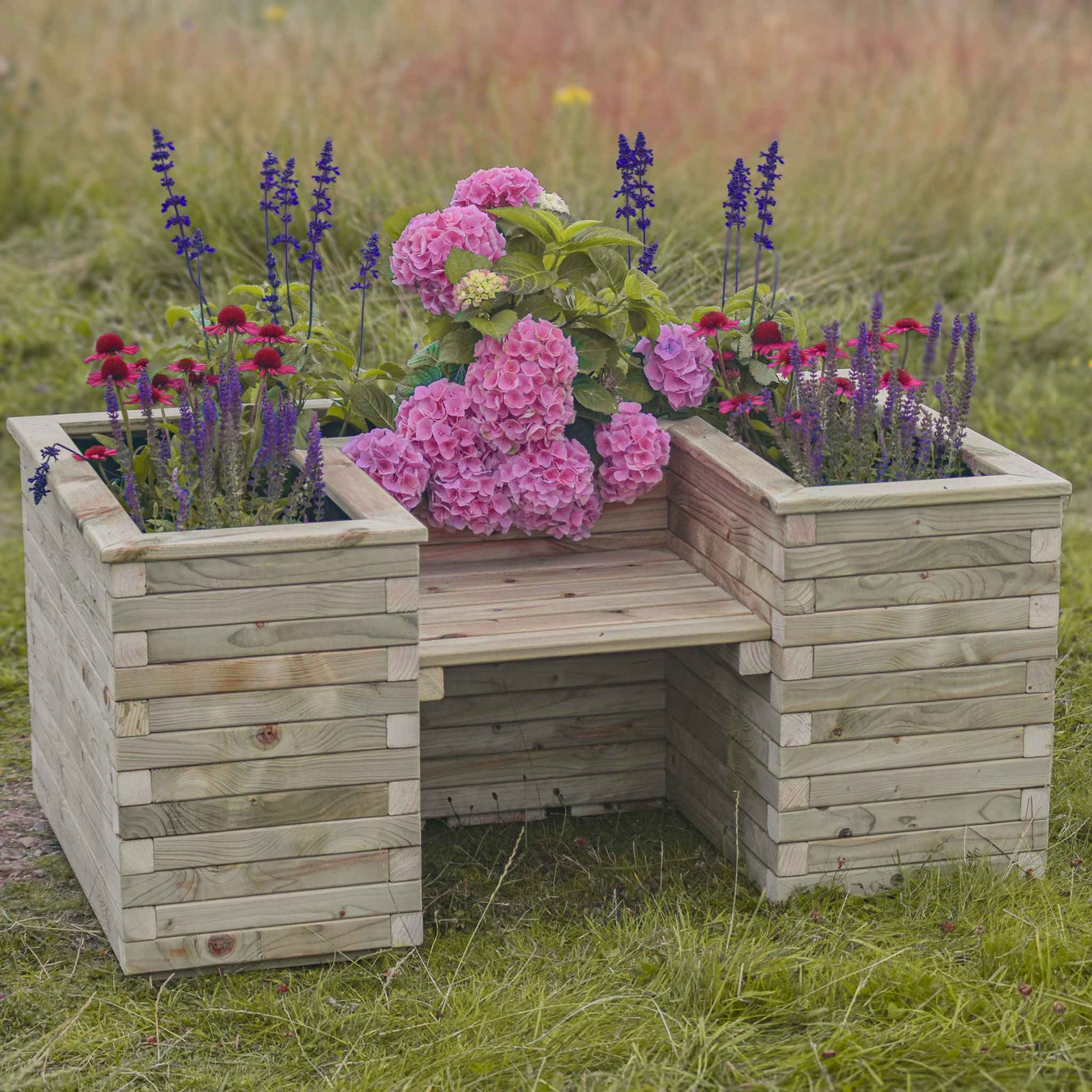 A sturdy U-shaped wooden planter with an integrated seat, filled with vibrant flowers. Crafted from high-quality durable timber, the planter bench features a sleek slatted design that combines functionality and style. Set in a picturesque outdoor setting with rolling hills in the background.