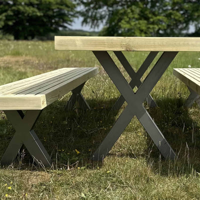 Close-up view of the wooden garden table with powder-coated steel X legs, showcasing the craftsmanship and sleek industrial design.