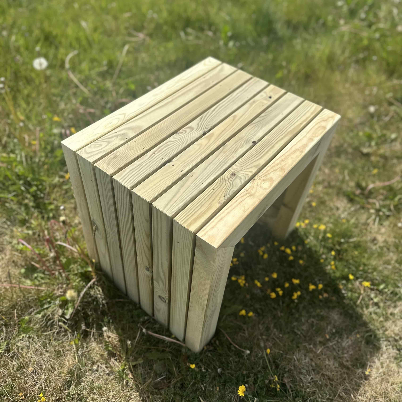 Close-up view of a wooden garden dining table stool, durable pine and modern mitred corners.