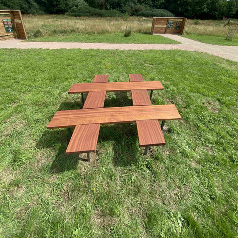 Hashtag shaped bespoke wooden bench placed on grass at the woodland trust.