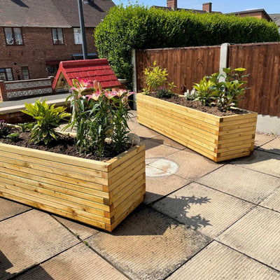 Two XXL Rectangular Garden Planters in a front garden full of soil and flowers. The durable wooden planters have a modern, sleek design.